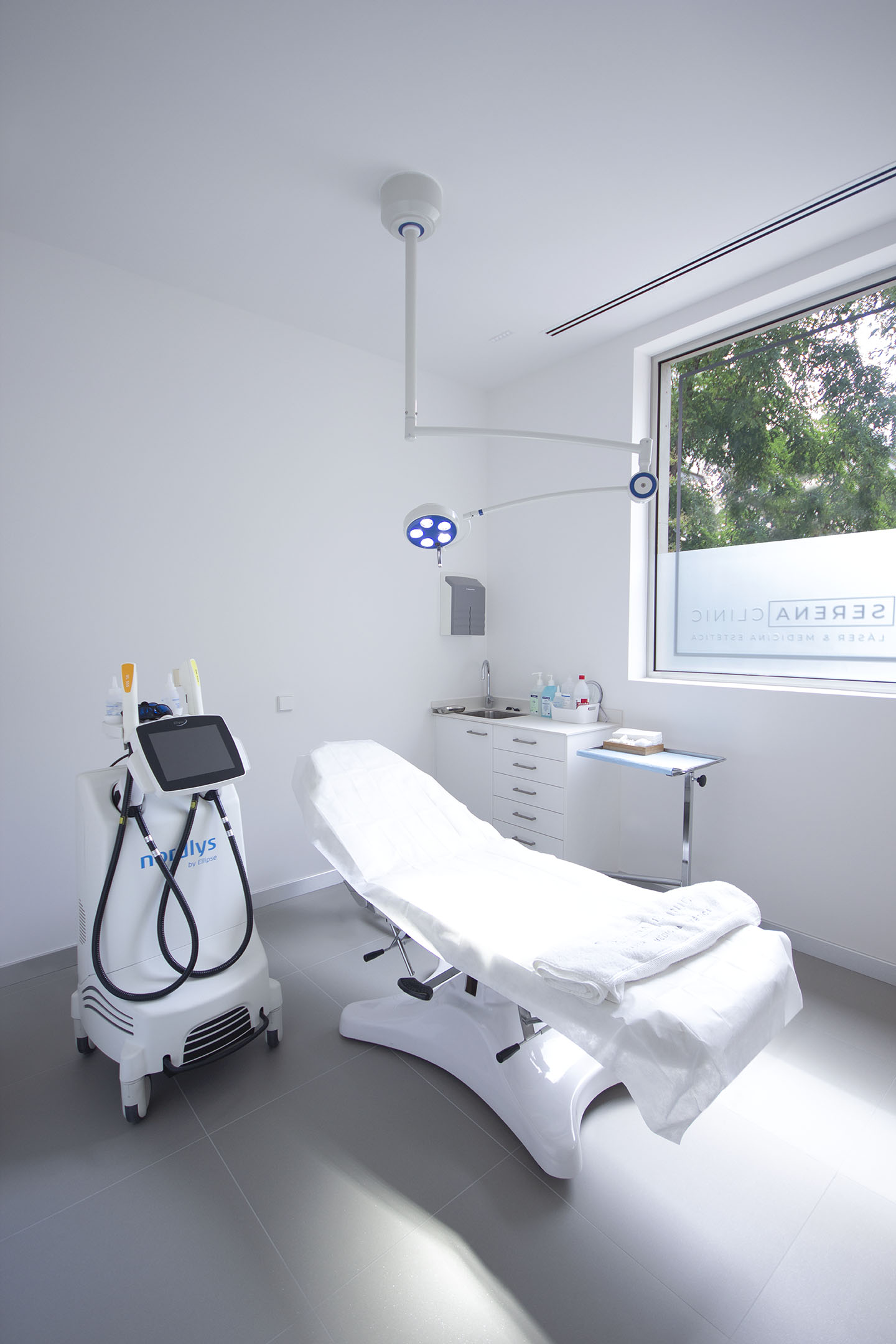 Sala de tratamiento de Serena Clinic con equipo láser junto a la camilla